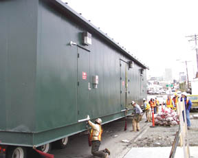 Workers prepare the Link's substation before a giant crane hoists it from the semi-trailer truck and positions it in place. (Photo by Brett Davis)