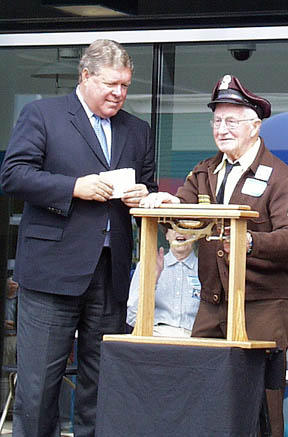 Cliff Fournier, 86, of Tenino, the last living trolley operator from the Tacoma Railway and Power Co., rings the bell that officially launches Tacoma Link light rail. To the left is U.S. Rep. Norm Dicks (D-6th District). (Photo by Brett Davis)