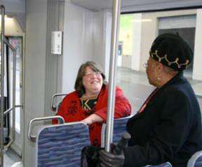 Lakewood City Councilmember Claudia Thomas (right) speaks with a Sound Transit Tacoma Link passenger during a trip through downtown on Tuesday. (Photo by Todd Matthews)