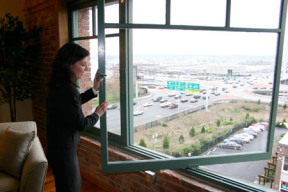 Andrea Masotti, vice president of Horizon Partners, Inc. demonstrates the swing-style windows inside one of the new Hunt Mottet lofts. (PHOTO BY TODD MATTHEWS)
