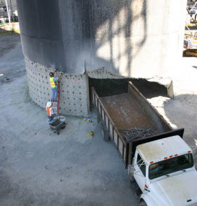 Darrell Ogden loads explosives into the base of a smokestack on the former Kaiser Aluminum site on the Port of Tacoma tideflats.  The 500-foot tower was demolished Sunday morning to make room for future growth at the port. (PHOTO BY TODD MATTHEWS)