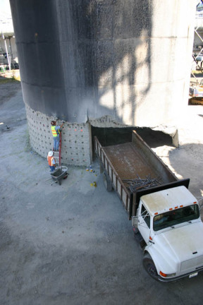 Darrell Ogden loads explosives into the base of a smokestack on the former Kaiser Aluminum site on the Port of Tacoma tideflats.  The 500-foot tower was demolished Sunday morning to make room for future growth at the port. (PHOTO BY TODD MATTHEWS)