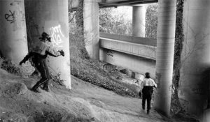 Downtown Tacoma BIA bike patrol officers Sarah Kirkman and John Leitheiser carefully make their way beneath I-705. They regularly inspect the area for homeless encampments. (PHOTO BY TODD MATTHEWS)