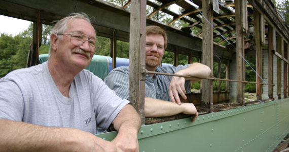 Tom and Vince Mendenhall, father-and-son owners of Arlington, Wash.-based Historic Railway Restoration, inside a  Turtleback streetcar that once operated on Tacoma streets. (PHOTO BY TODD MATTHEWS)