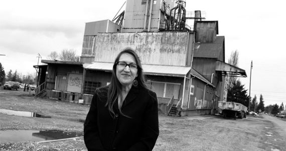 An improved historic preservation program in Pierce County could help Midland community activist Stacy Emerson, who stands in front of a former feed terminal, one of several old buildings slated for demolition. For two years, Emerson has tried to get her own 1918 building, the oldest commercial property in Midland, on Pierce County's historic register. (PHOTO BY TODD MATTHEWS)