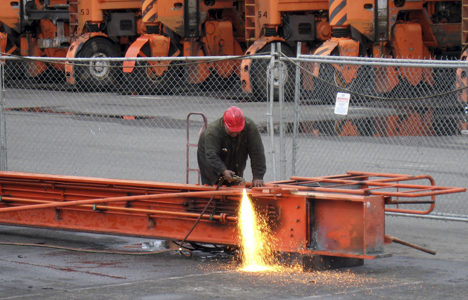 A worker separates pieces of a straddle carrier leg. (PHOTO COURTESY PORT OF TACOMA)