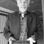 Building owner Steven Nikolich holds a plaque showing the building's age and architects. (PHOTO BY TODD MATTHEWS)