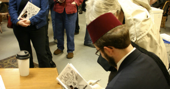 R. R. Anderson signs copies of his book of political cartoons at King's Books in Tacoma. (PHOTO BY TODD MATTHEWS)