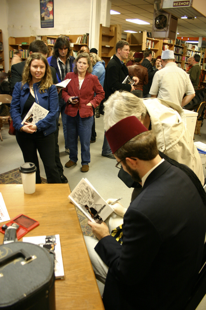 R. R. Anderson signs copies of his book of political cartoons at King's Books in Tacoma. (PHOTO BY TODD MATTHEWS)