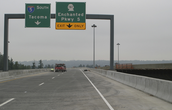 A contractor puts finishing touches on the first of two fly over ramps between Interstate 5 and State Route 18 in Federal Way.