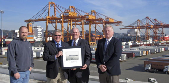 International Longshore and Warehouse Union (ILWU) Local 23 President Scott Mason (second from left) presented NYK Line (North America) President Bill Payne (second from right) with a historical photo of the ship's first visit. (PHOTO COURTESY PORT OF TACOMA)