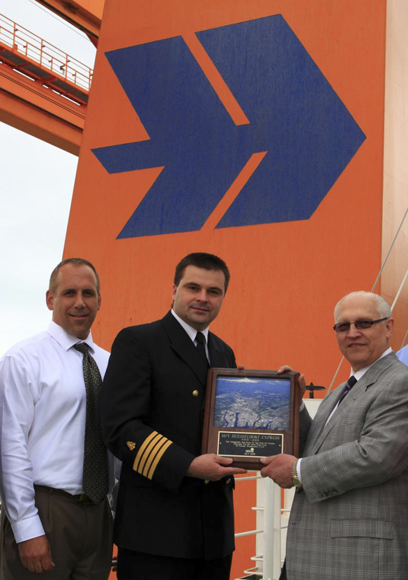 In July, Port of Tacoma Commissioner Don Johnson (far right) and Port CEO John Wolfe (far left) presented Hapag-Lloyd's Dusseldorf Express Captain Detlef Rose (center) with a plaque to commemorate the vessel's first call to Tacoma. (PHOTO COURTESY PORT OF TACOMA)