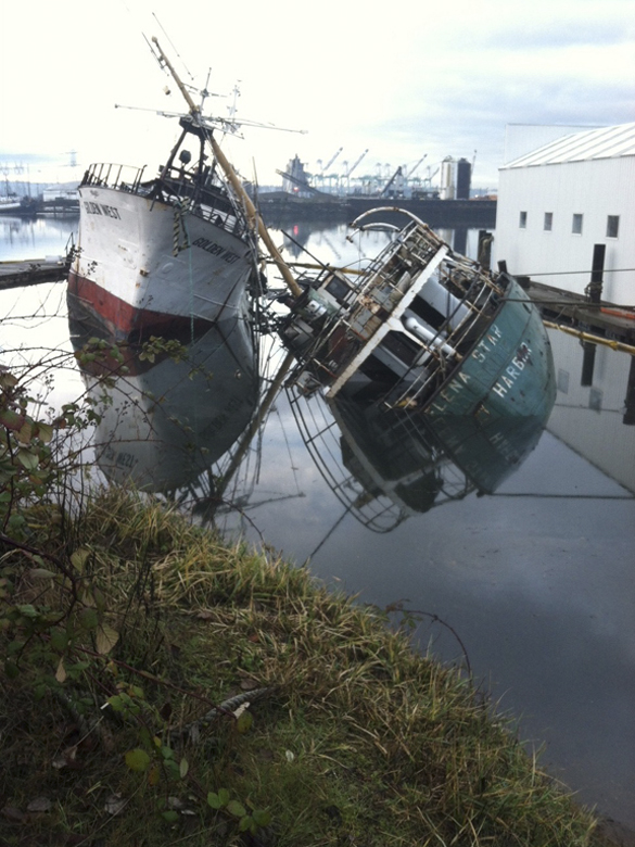 The Washington Department of Ecology (Ecology) and the U.S. Coast Guard are working with Ballard Diving and Salvage to contain a small amount of oil released to the Hylebos Waterway after two vessels moored at Mason Marine near Tacoma began sinking early Friday. (PHOTO COURTESY WASHINGTON STATE DEPARTMENT OF ECOLOGY)