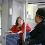 DECEMBER 2004 | Lakewood City Councilmember Claudia Thomas (right) speaks with a Sound Transit Tacoma Link light rail passenger during a trip through downtown Tacoma following a celebration to mark Link's one-millionth passenger. (TACOMA DAILY INDEX FILE PHOTO BY TODD MATTHEWS)