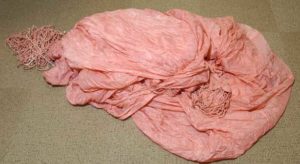 The pink nylon parachute canopy from the FBI case file on Dan "D.B." Cooper. Several shroud lines from this canopy were cut off by the hijacker. The parachute canopy is from one of two "reserve parachutes" of four parachutes total provided to the hijacker as part of his demands. (PHOTO COURTESY WASHINGTON STATE HISTORICAL SOCIETY)