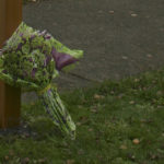 A bouquet of flowers were left at the base of the new street sign on Tuesday morning. (PHOTO BY TODD MATTHEWS)
