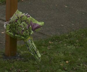 A bouquet of flowers were left at the base of the new street sign on Tuesday morning. (PHOTO BY TODD MATTHEWS)