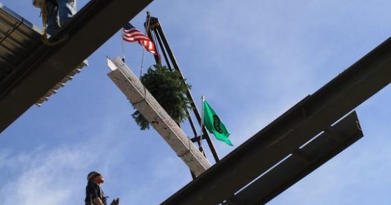 With a drum roll and roaring applause, Tacoma Art Museum raised the final steel beam into place Wednesday afternoon for its building expansion as part of the upcoming Haub Family Galleries. As is building tradition, the beam, signed by supporters of the museum and community members, was adorned with a tree and American and Washington State flags and then lifted high into the web of steel structures that have taken shape on Pacific Avenue. (PHOTO COURTESY TACOMA ART MUSEUM)