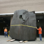 Employees working for D & D Construction prepare to move one section of the three-ton, 15-foot-tall, 22-foot-wide bronze-and-steel Sun King sculpture out of storage at the City of Tacoma's Fleet Operations Headquarters and onto flatbed trailers for transport to a public park near Thea Foss Waterway. (PHOTO BY TODD MATTHEWS)