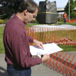 City of Tacoma Public Works Project Engineer Dan Cederlund reviews the plans for placement of Tom Morandi's Sun King sculpture in a park near Thea Foss Waterway. (PHOTO BY TODD MATTHEWS)