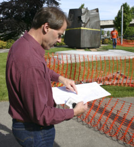 City of Tacoma Public Works Project Engineer Dan Cederlund reviews the plans for placement of Tom Morandi's Sun King sculpture in a park near Thea Foss Waterway. (PHOTO BY TODD MATTHEWS)