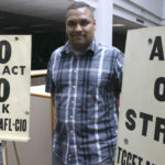 Coleman displays the picket signs used by former TCC history professor Murray Morgan during a faculty strike in the 1970s. (PHOTO BY TODD MATTHEWS)