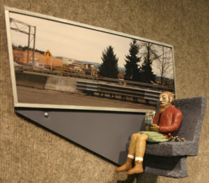 Local artist Lynn Di Nino's exhibit at Tacoma Public Library's Handforth Gallery is entitled 'Riding the express bus Seattle/Tacoma' and consists of 14 vignettes of three-dimensional 10-inch, wall-mounted figures seated next to photographs of landmarks Di Nino captured using her smart phone while riding the bus between Seattle and Tacoma. (PHOTO BY TODD MATTHEWS)