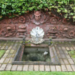 A brick wall bordering a backyard garden at the Mead House includes terra cotta tiles and a figurehead of a helmeted firefighter (known as the 'Head of Mercury') that were salvaged from the former Fire Station No. 6 in downtown Tacoma, which was built in 1890. The fire station was damaged during an earthquake in 1949 and demolished in 1974. (PHOTO COURTESY SUSAN JOHNSON / ARTIFACTS CONSULTING)