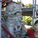 Chinese Reconciliation Project Foundation President Theresa Pan Hosley points out a stone lion statue damaged by vandals. (PHOTO BY TODD MATTHEWS)