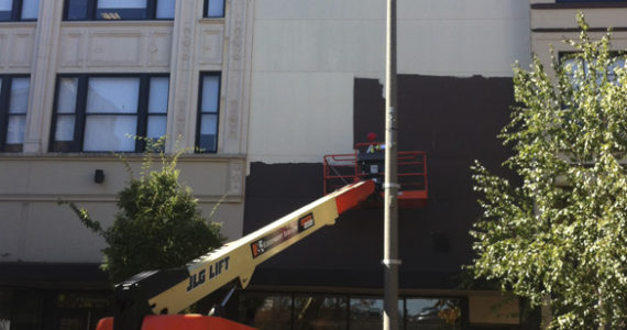 Work is under way this week to install art on a bare wall located between two historic buildings in Tacoma's Theater District. (PHOTO BY TODD MATTHEWS)