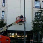 Contractors blocked off a small section of Broadway last month to make room for a mechanical lift that allowed workers to paint the building facade and drill holes in preparation for the artwork. (PHOTO COURTESY JONATHAN CLARREN).