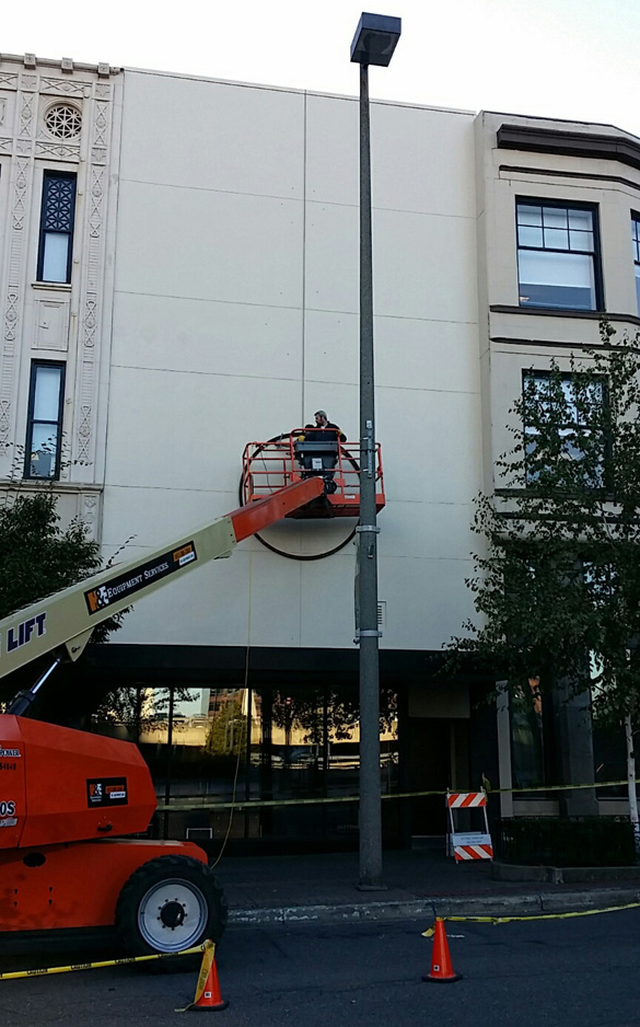 Contractors blocked off a small section of Broadway last month to make room for a mechanical lift that allowed workers to paint the building facade and drill holes in preparation for the artwork. (PHOTO COURTESY JONATHAN CLARREN).