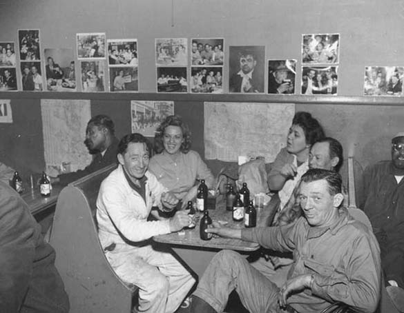 Customers crowd into a booth at the Banquet Tavern near Seattle's Chinatown in 1955. Ogawa's photographs are posted on the wall above the booths. (ELMER OGAWA PHOTOGRAPH / COURTESY UNIVERSITY OF WASHINGTON SPECIAL COLLECTIONS)