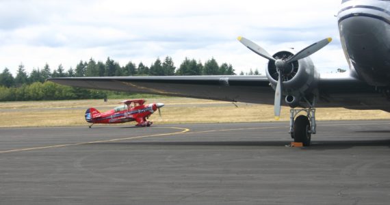 "The Flying Tenor", Will Allen of Renton, taxis his Pitts Special biplane past a vintage DC-3 at Tacoma Narrows Airport, Saturday, July 2. Credit: David Guest / TDI