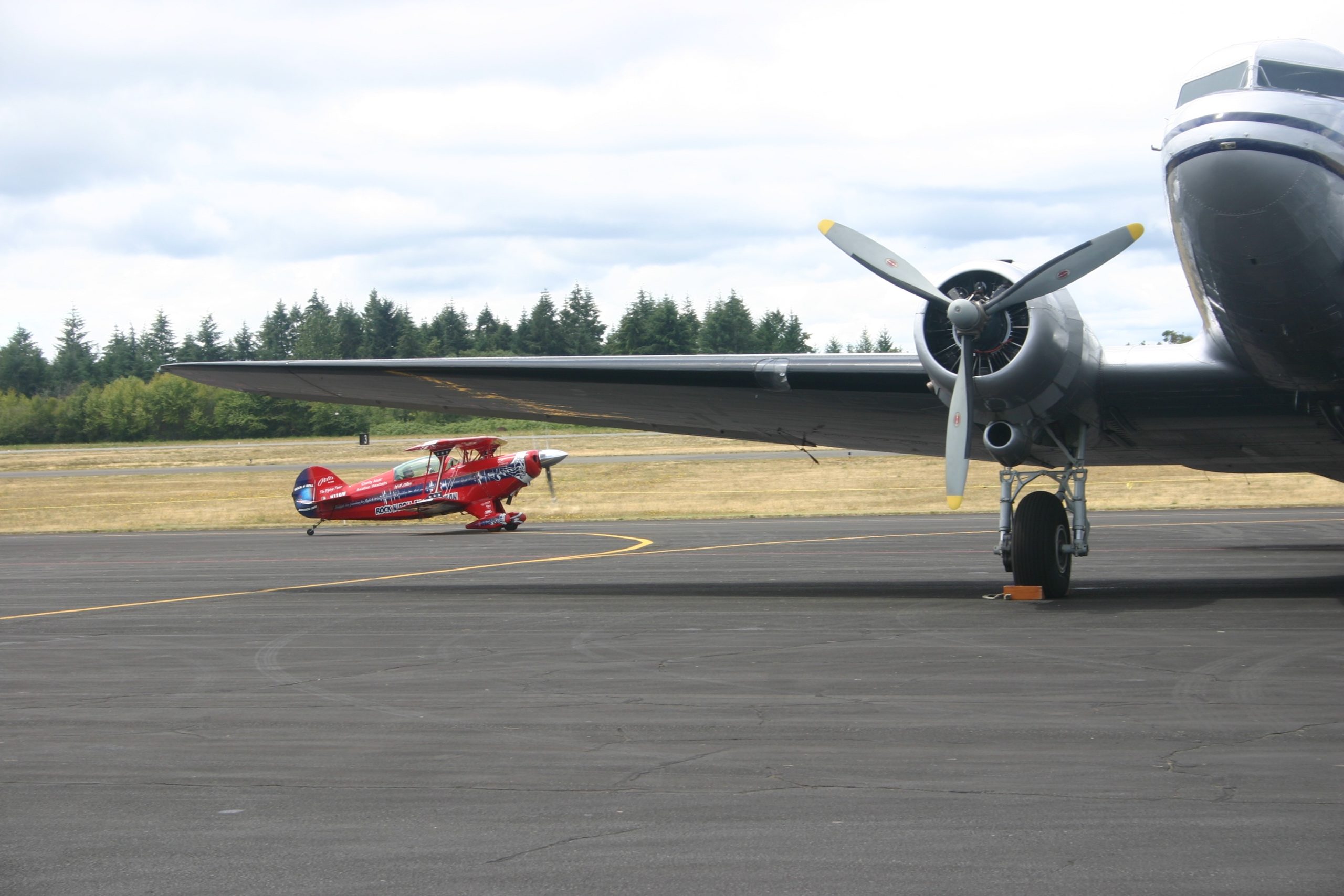 "The Flying Tenor", Will Allen of Renton, taxis his Pitts Special biplane past a vintage DC-3 at Tacoma Narrows Airport, Saturday, July 2. Credit: David Guest / TDI