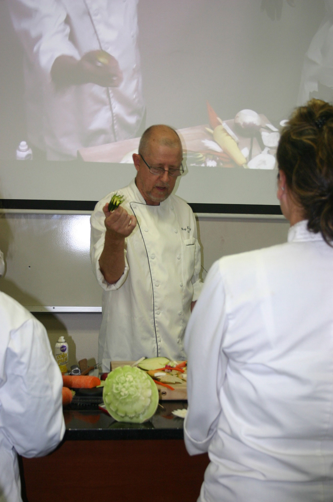 Visiting culinary artist Ray Duey shows Bates College students how to garnish fruits and vegetables. Credit: David Guest / TDI