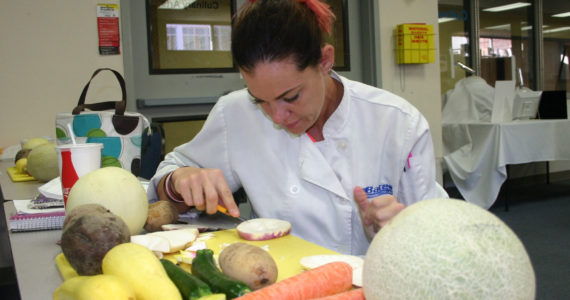 Bates Technical College culinary student Jeanette Harder carves a turnip slice into a flower during class. Credit: David Guest / TDI