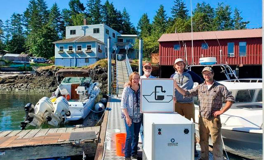 <p>Shaw Island General Store owners Terri and Steve Mason and employees Nick Burne and Jonathan Hogue stand by the pumpout facility that was installed last summer. Image courtesy Washington Sea Grant</p>