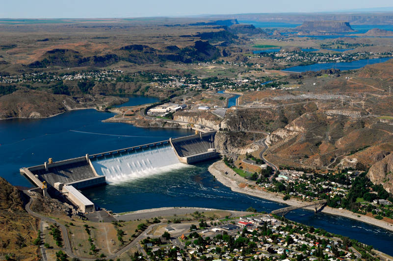 June 30, 2011: Aerial view of Grand Coulee Dam releasing downstream an unusually large and late spring time water flows of over 200,000 cfs. Broken out, it’s 33,800 cfs, over the spillway and 167,000 cfs through the hydropower generators. Image courtesy Bureau of Reclamation