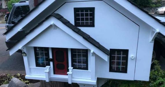 This is actually a Little Free Library in the shape of a ‘traditional’ home. It reflects the assumptions of what a house in this neighborhood should look like. (Photo by Morf Morford)