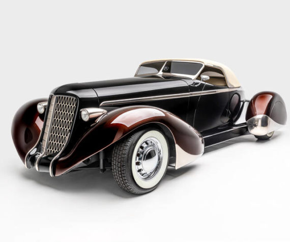 <p>“SLOW BURN”</p>
<p>SPECS: 1936 AUBURN 852 BOATTAIL SPEEDSTER (MODERN REPLICA) BUILDER: RICK DORE KUSTOMS INTERIOR: EGYPTIAN LEATHER BY BOB DEVINE/RICK DORE ENGINE: 350-CUBIC INCH CHEVROLET V-8</p>
<p><em>Image courtesy LeMay-America’s Car Museum, Petersen Automotive Museum and the Hetfield Family</em></p>
<p>Bio: “Slow Burn” was crafted from an official Glen Pray recreation of an Auburn Boattail. The fiberglass body made it difficult to alter extensively, so Hetfield and Dore instead added details, like a sloped, Carson-style convertible top, to emphasize the car’s curving lines. The root beer paint color of the fenders, in contrast with the darker body color, highlights their sinuous shape. Accents like the geometric grille, taillight trim, and personally designed wheels exemplify Hetfield’s personal style.</p>
