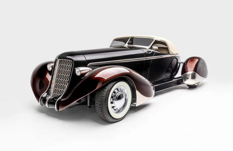 <p>“SLOW BURN”</p>
<p>SPECS: 1936 AUBURN 852 BOATTAIL SPEEDSTER (MODERN REPLICA) BUILDER: RICK DORE KUSTOMS INTERIOR: EGYPTIAN LEATHER BY BOB DEVINE/RICK DORE ENGINE: 350-CUBIC INCH CHEVROLET V-8</p>
<p><em>Image courtesy LeMay-America’s Car Museum, Petersen Automotive Museum and the Hetfield Family</em></p>
<p>Bio: “Slow Burn” was crafted from an official Glen Pray recreation of an Auburn Boattail. The fiberglass body made it difficult to alter extensively, so Hetfield and Dore instead added details, like a sloped, Carson-style convertible top, to emphasize the car’s curving lines. The root beer paint color of the fenders, in contrast with the darker body color, highlights their sinuous shape. Accents like the geometric grille, taillight trim, and personally designed wheels exemplify Hetfield’s personal style.</p>