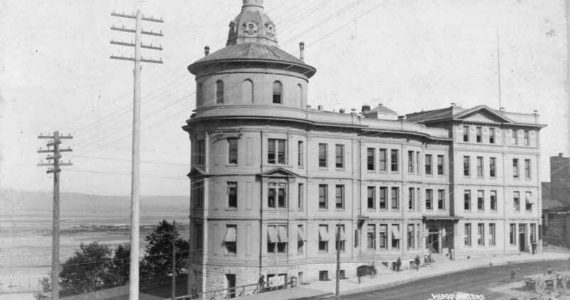 Northern Pacific Headquarters at 621 Pacific Avenue, circa 1889. The railroad had chosen Tacoma as its western terminus in 1873; from that point, the city would grow furiously from a small hamlet to a metropolis of about 30,000 by 1890. Construction of Northern Pacific’s stone and brick headquarters with its distinctive tower, located on the bluff overlooking their half-moon railroad yards, began in the summer of 1887 and was completed the following year. Its 53 offices and storerooms and 19 vaults were utilized by the Tacoma Land Company, Weyerhaeuser Company and Northern Pacific. Northern Pacific would sell the building to the City of Tacoma in 1922 as the railroad planned to move its offices to Seattle. Photo and commentary courtesy of Tacoma Public Library, TPL-10172