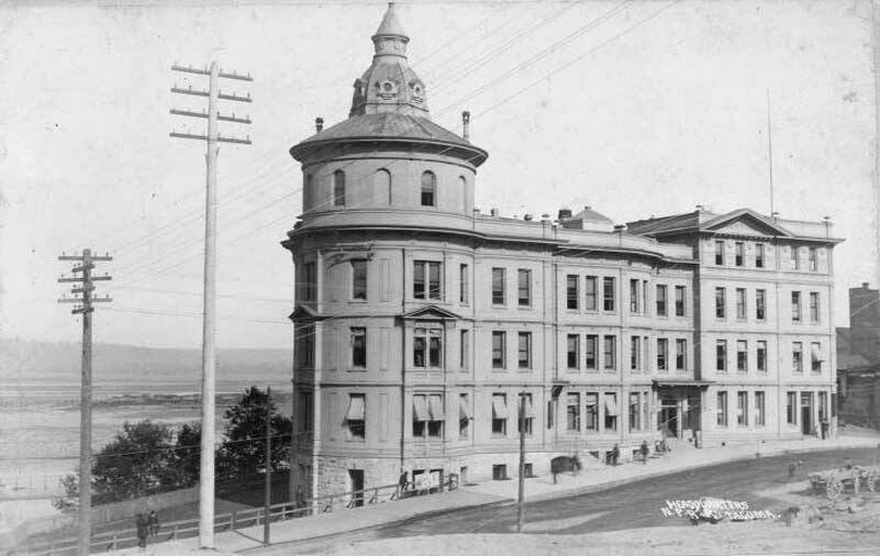 Northern Pacific Headquarters at 621 Pacific Avenue, circa 1889. The railroad had chosen Tacoma as its western terminus in 1873; from that point, the city would grow furiously from a small hamlet to a metropolis of about 30,000 by 1890. Construction of Northern Pacific’s stone and brick headquarters with its distinctive tower, located on the bluff overlooking their half-moon railroad yards, began in the summer of 1887 and was completed the following year. Its 53 offices and storerooms and 19 vaults were utilized by the Tacoma Land Company, Weyerhaeuser Company and Northern Pacific. Northern Pacific would sell the building to the City of Tacoma in 1922 as the railroad planned to move its offices to Seattle. Photo and commentary courtesy of Tacoma Public Library, TPL-10172