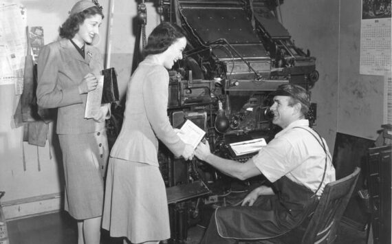 <strong>A Linotype machine is in the background of this image from a 1944 Community War Chest campaign. View of two unidentified War Chest volunteers soliciting funds from an unidentified typesetter. Image courtesy Northwest Room at The Tacoma Public Library, image number: Richards Studio D18294-11</strong>