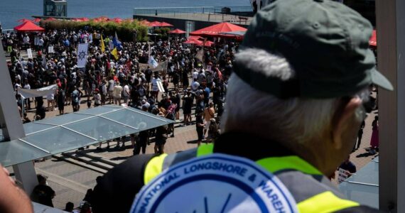 A striking port worker from the International Longshore and Warehouse Union Canada views the large gathering attending a rally in Vancouver, on Sunday, July 9, 2023. THE CANADIAN PRESS/Ethan Cairns