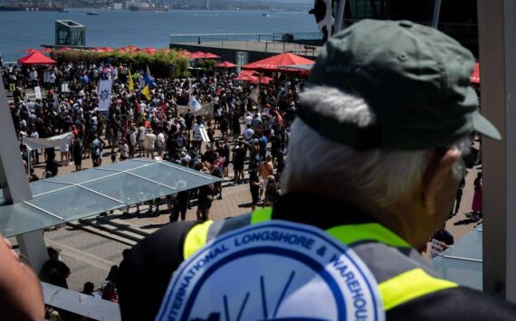 A striking port worker from the International Longshore and Warehouse Union Canada views the large gathering attending a rally in Vancouver, on Sunday, July 9, 2023. THE CANADIAN PRESS/Ethan Cairns