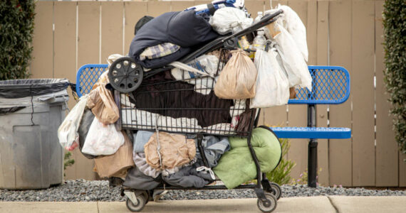Homeless persons belongings in a shopping cart in a sidewalk