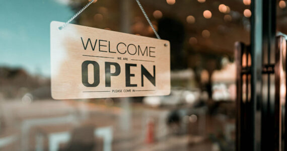 Open cafe or restaurant. Open sign board on glass door in modern cafe coffee shop