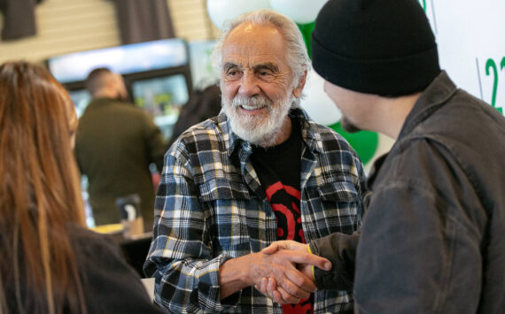 Tommy Chong shakes hands with Selena Morales and Elijah Harrison, both of Arlington, after taking a photo with them and giving them a couple signatures during 210 Cannabis Co’s grand opening in 2022 in Arlington, Washington. (Sound Publishing file photo)